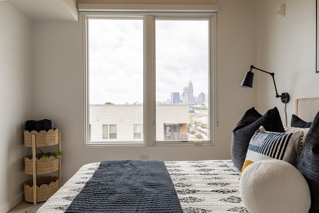 A bedroom with a large bed and a view of the city.
