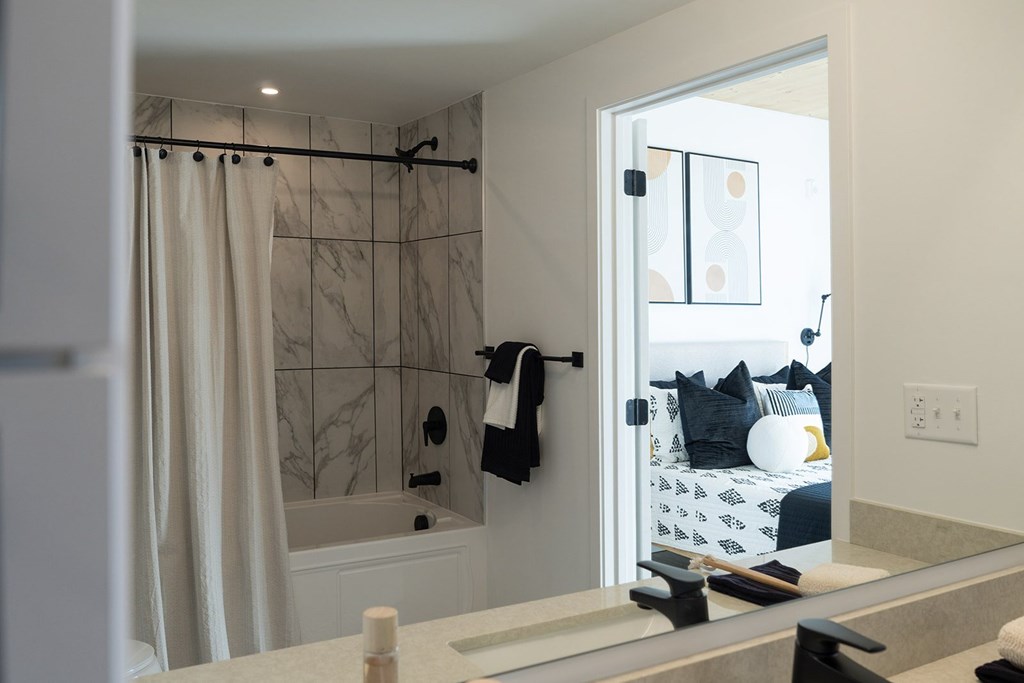 A bathroom with a shower and a mirror.