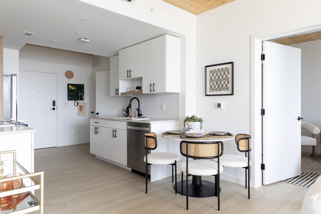 A modern kitchen with a dining table set for two.