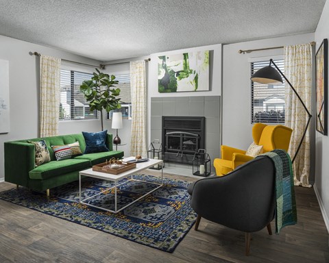 a living room with a green couch and yellow chairs