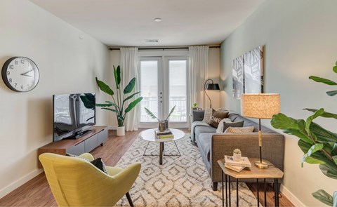 A living room with a yellow chair and a television.