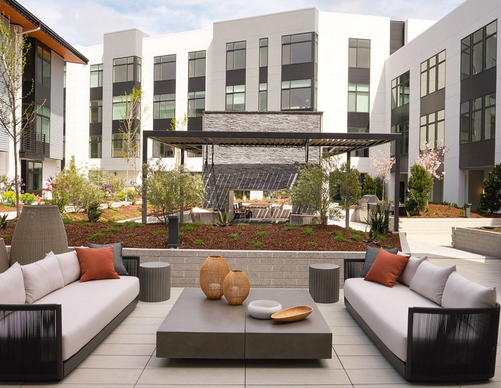 a seating area with couches and a coffee table in front of a building
