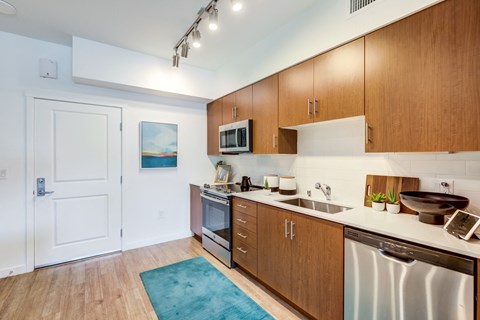 a kitchen with wooden cabinets and stainless steel appliances and a sink