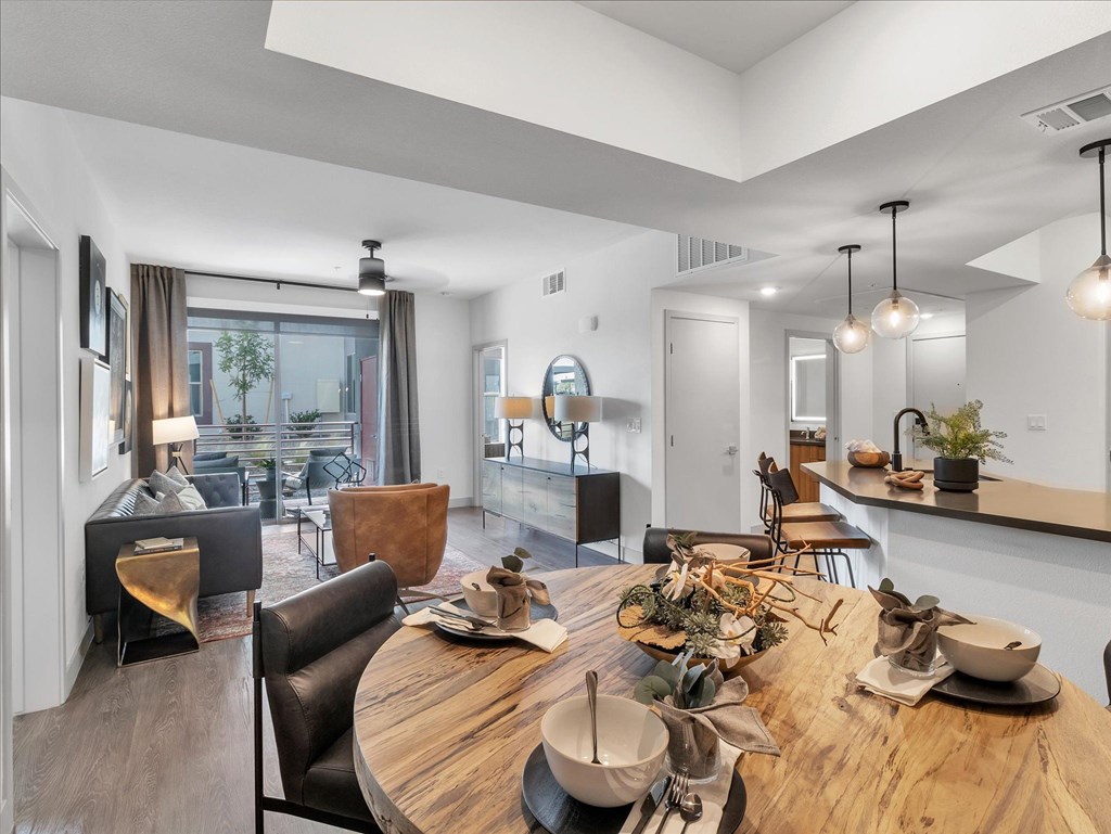 A modern dining room with a wooden table set for a meal.