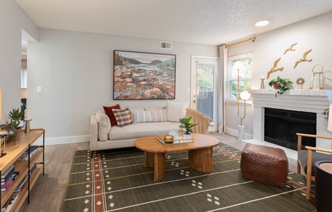 A living room with a white couch, a coffee table, and a painting on the wall.
