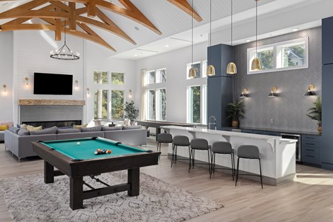 A billiard table is in the middle of a living room.