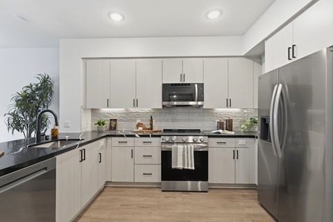 A modern kitchen with stainless steel appliances and white cabinets.