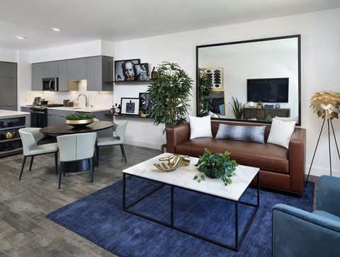 A modern living room with a brown leather couch and a white coffee table.