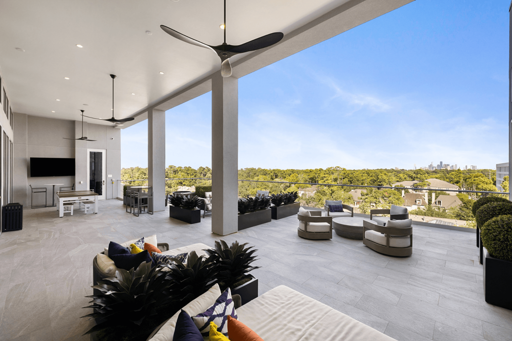 A modern living room with a large window and a ceiling fan.
