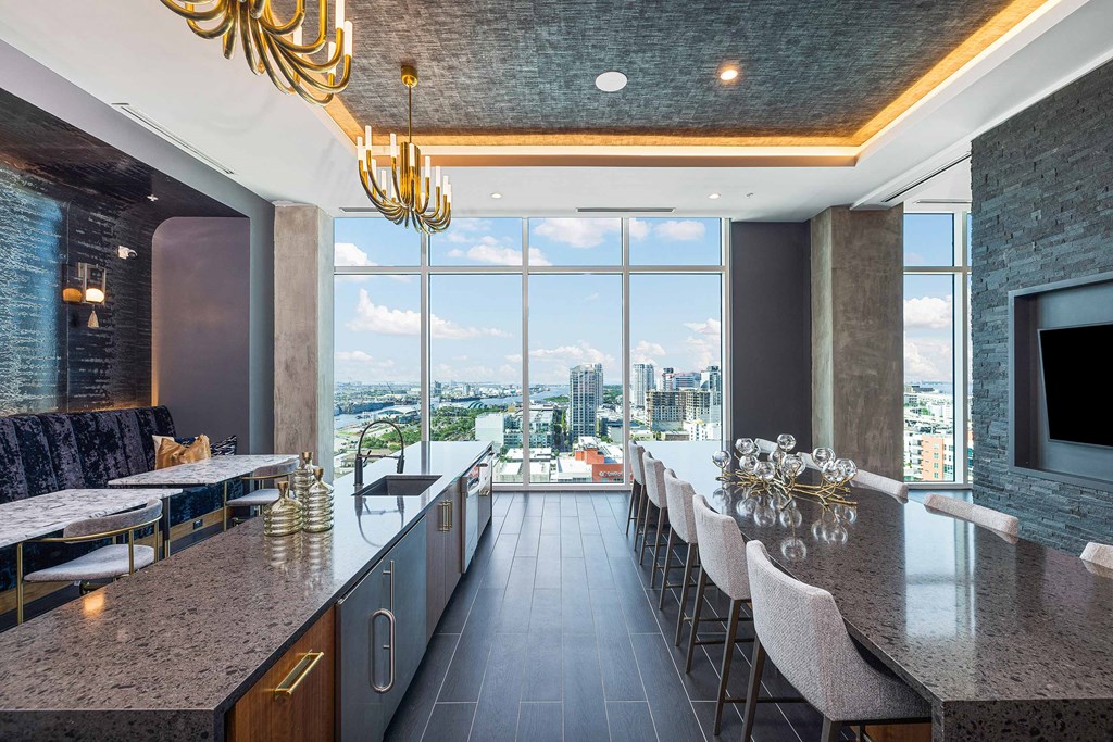 a kitchen with a long bar and a view of the city