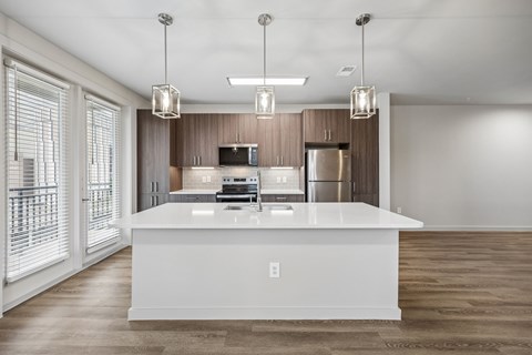 A modern kitchen with a white island in the middle.