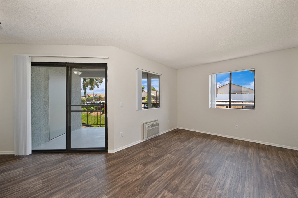 a 1-bedroom apartment living room with wood floors and sliding glass door