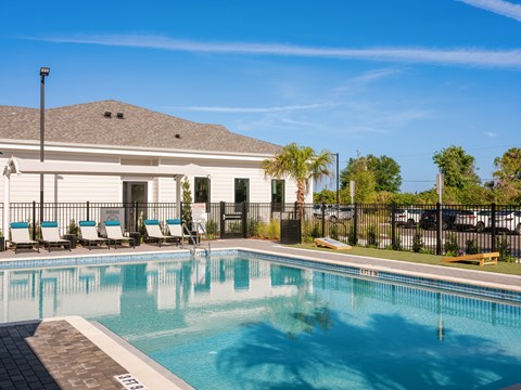 A pool with a white building behind it.