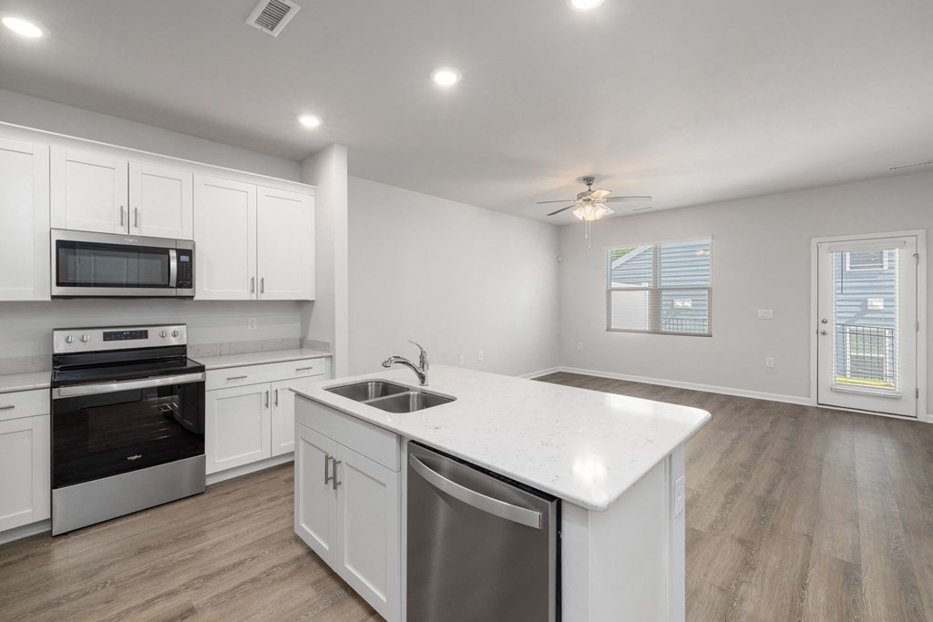 a renovated kitchen with white cabinets and stainless steel appliances