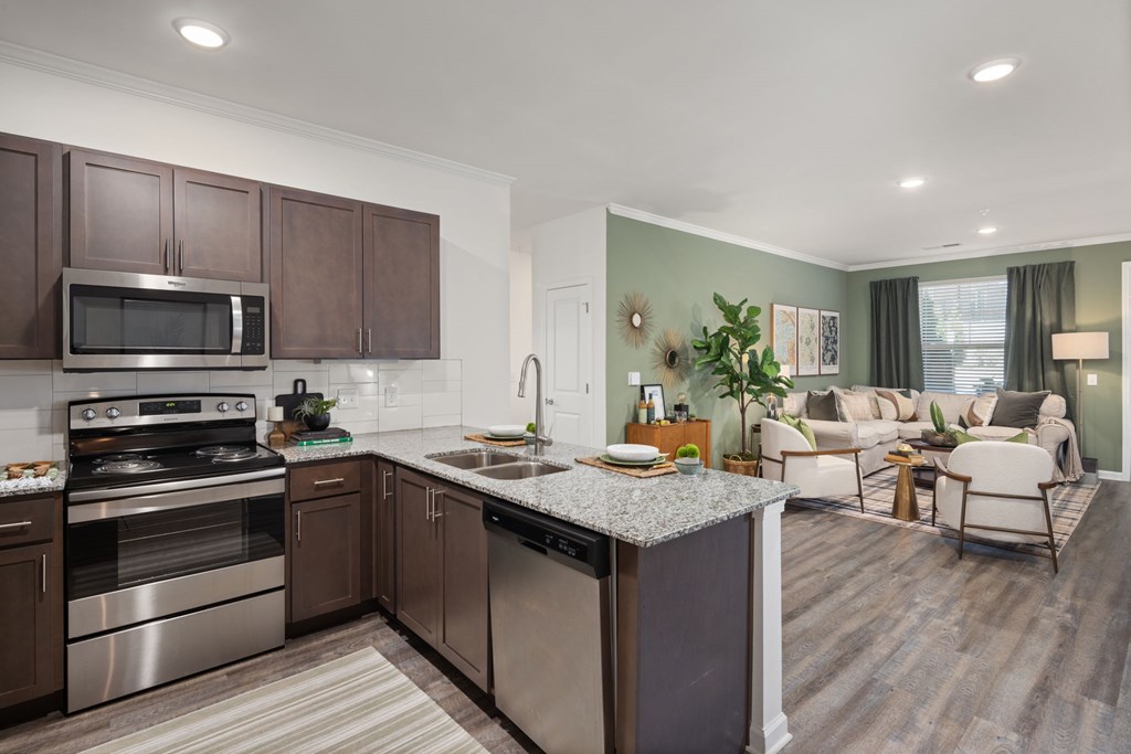 A modern kitchen with dark brown cabinets and stainless steel appliances.