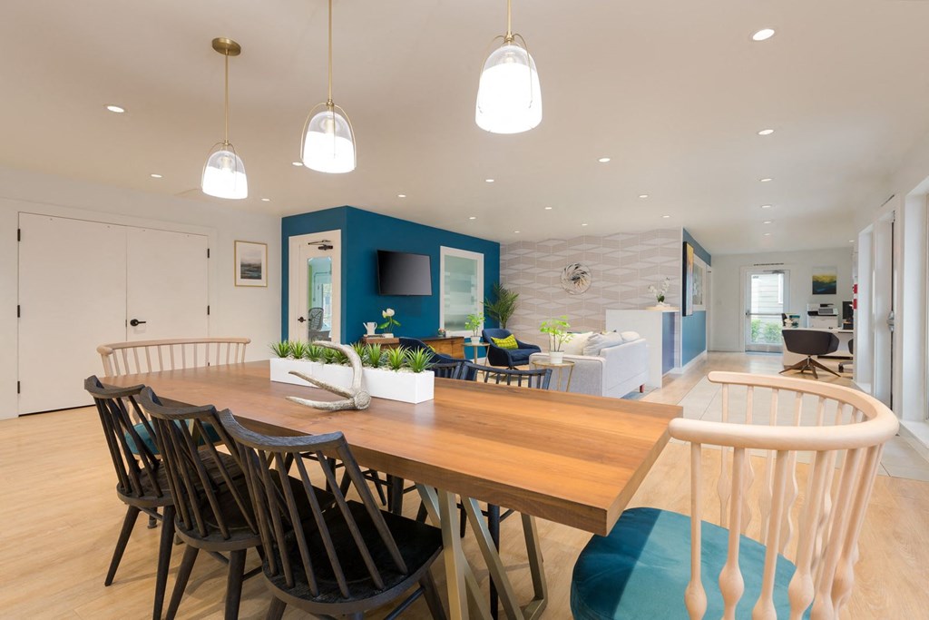 a dining area with a wooden table and chairs and a blue accent wall