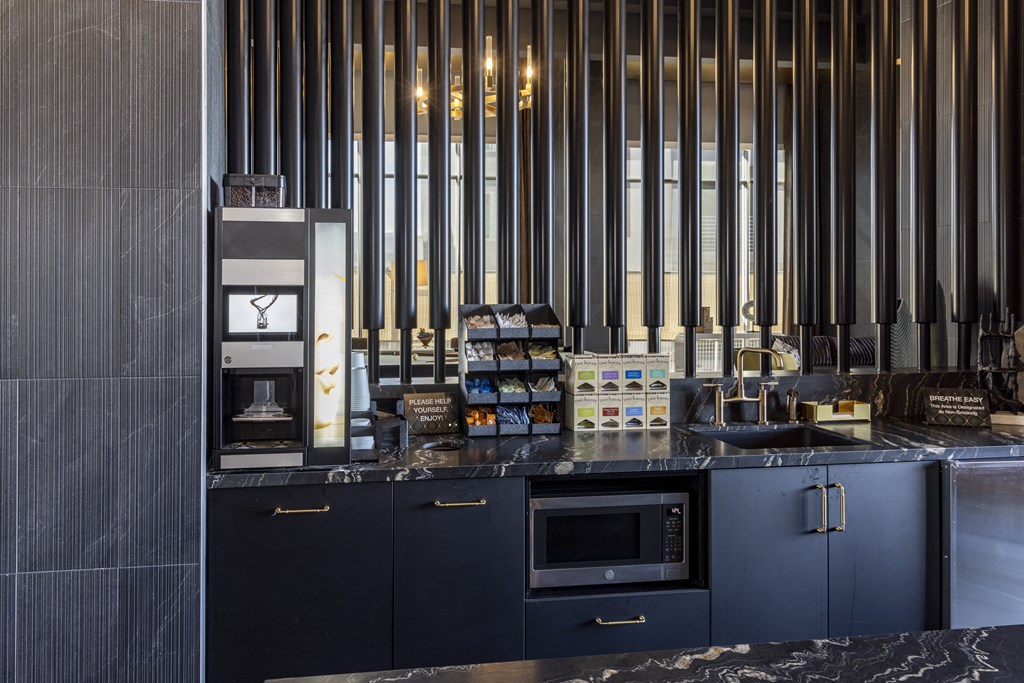 A modern kitchen with dark cabinets and a black countertop.