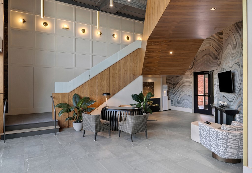 A modern living room with a staircase and a TV.
