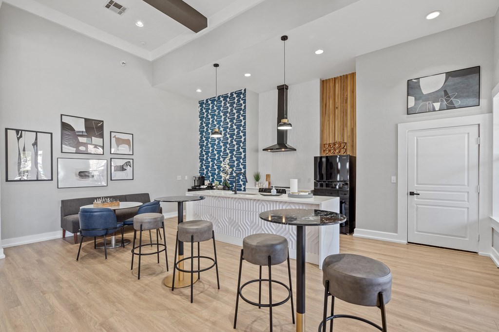 a living room with a kitchen and a bar with four stools