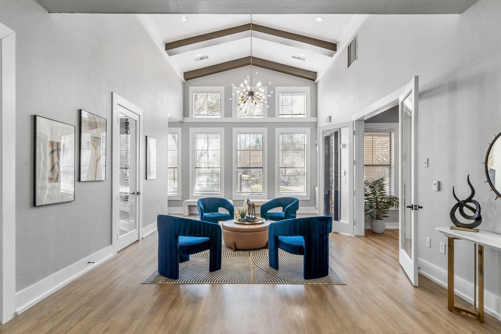 a living room with blue chairs and a round table