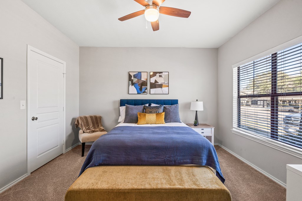 a bedroom with a bed and a ceiling fan