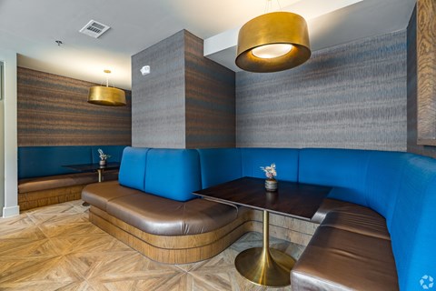 A modern dining area with a wooden table and blue booths.