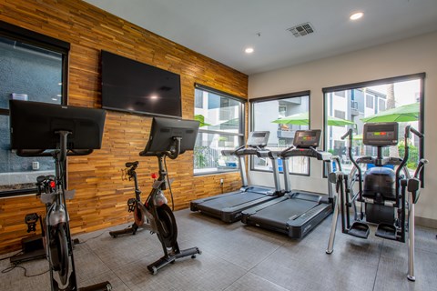 A fitness center with treadmills, exercise bikes, and a television at Ascent North Scottsdale apartments in North Scottsdale.