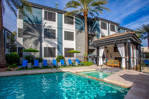 A resort-style pool framed by palm trees at Ascent North Scottsdale, apartments in North Scottsdale.