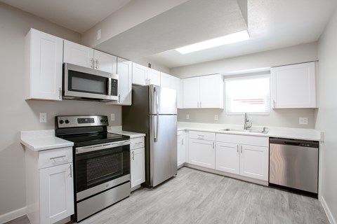 A kitchen with white cabinets and stainless steel appliances.