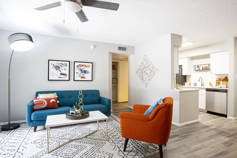 A living room with a blue couch and an orange chair.