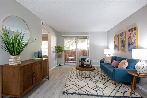 A living room with a blue couch and a wooden cabinet.