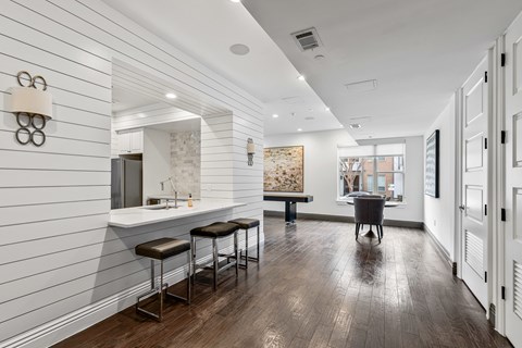 A long, narrow room with a bar area and a dining table.