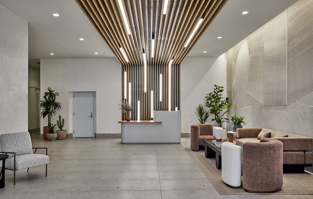 a lobby with couches and chairs and potted plants