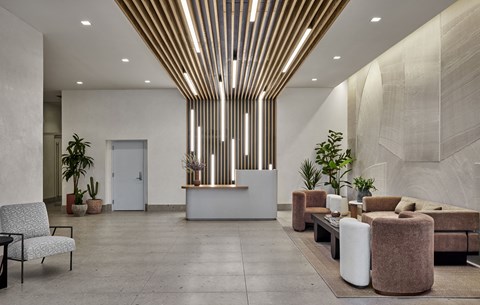 a lobby with couches and chairs and potted plants