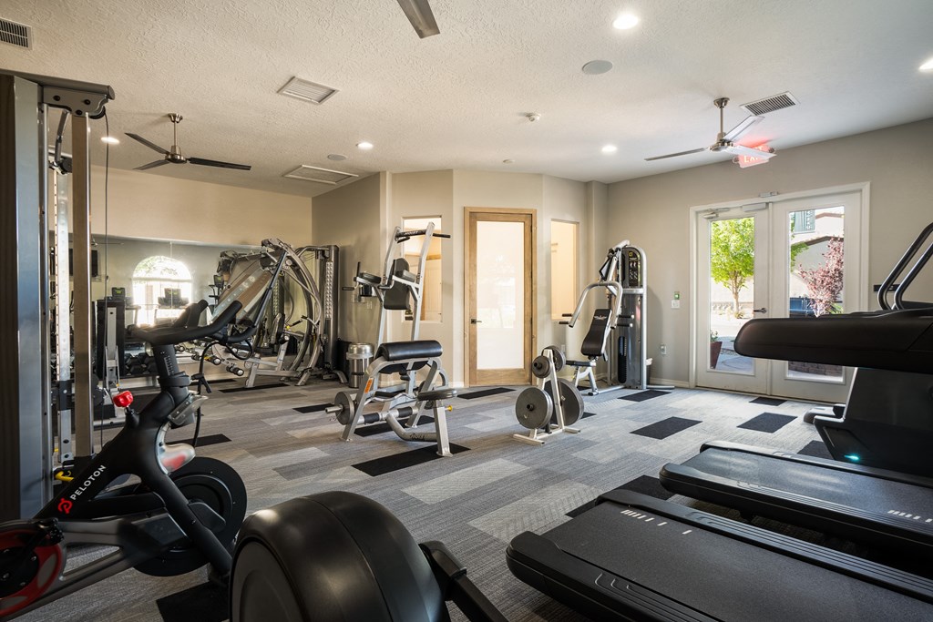 a gym with treadmills and other exercise equipment and a glass door