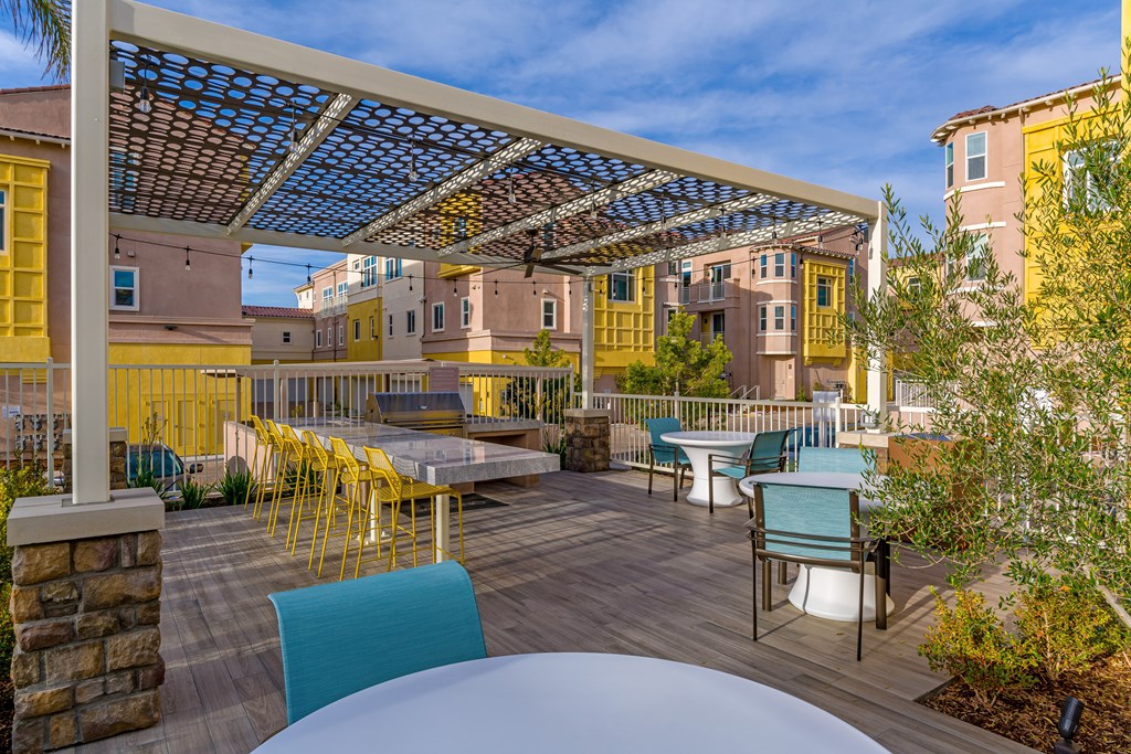 A patio with a table and chairs under a roof.