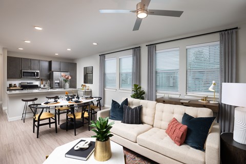 a living room with a white couch and a kitchen with a table and chairs