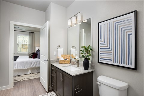 a bathroom with a large mirror and a toilet and a sink