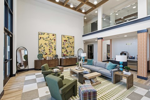 A living room with a checkered floor and a grey couch.
