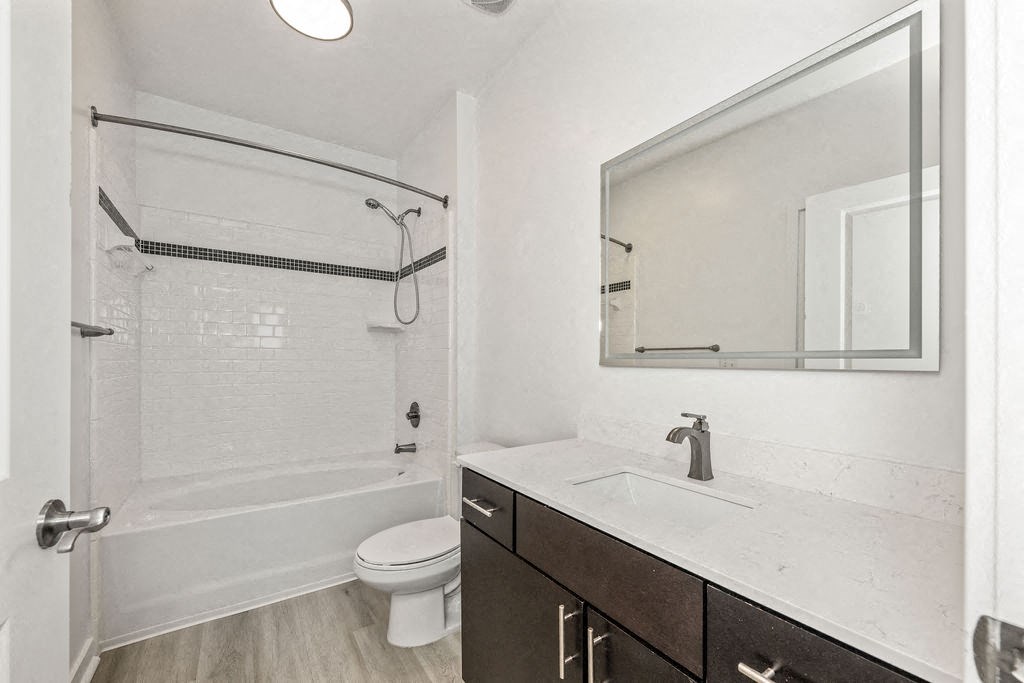 A white bathroom with a toilet, sink, and shower.