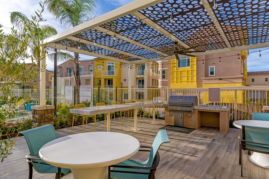 A patio with a table and chairs under a blue and white canopy.