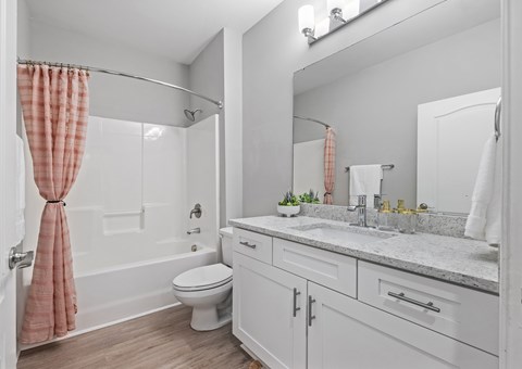 A bathroom with a toilet, sink, and shower.