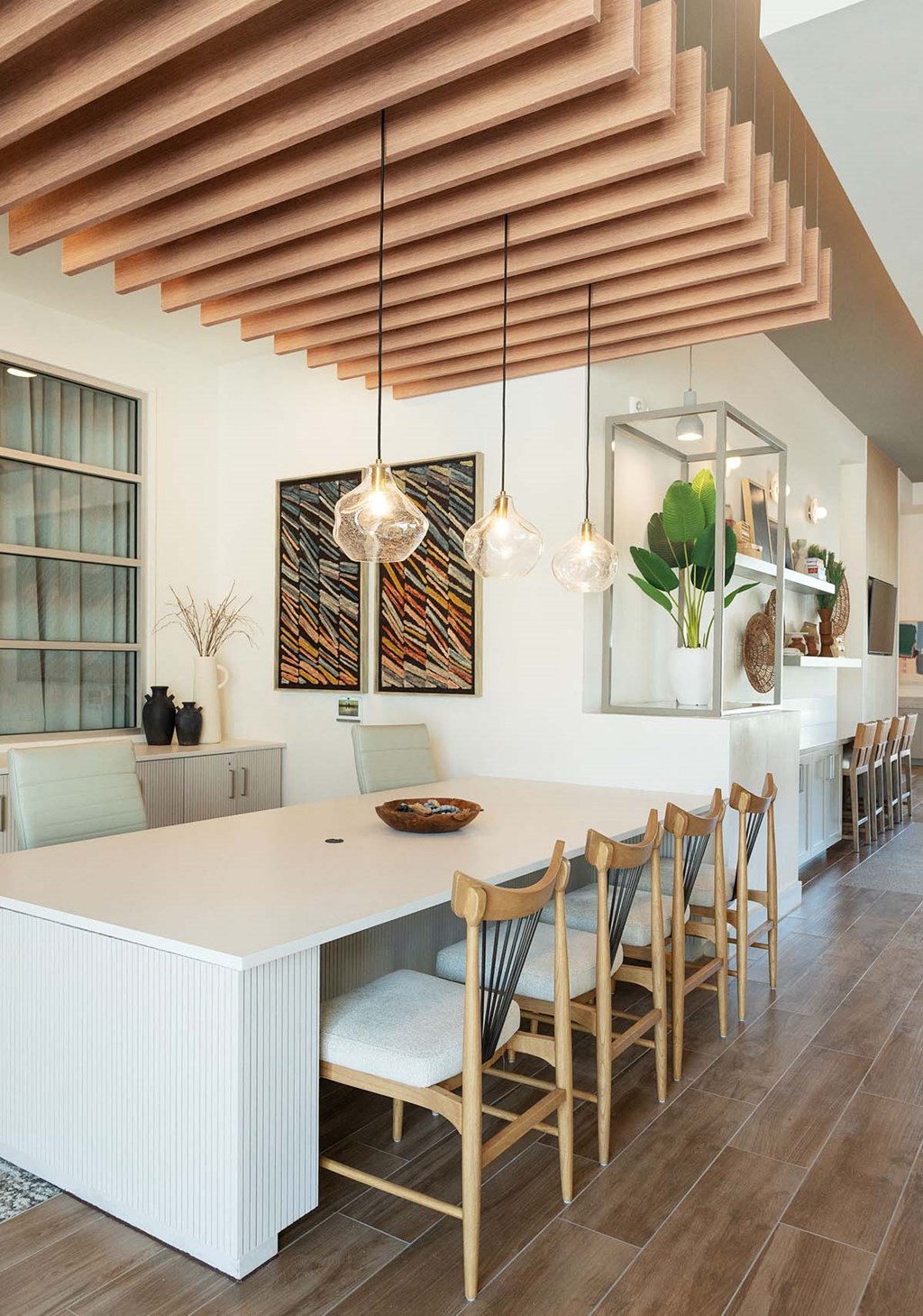 a dining room with a long white table and chairs