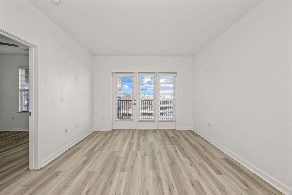 A room with a window and wooden flooring.