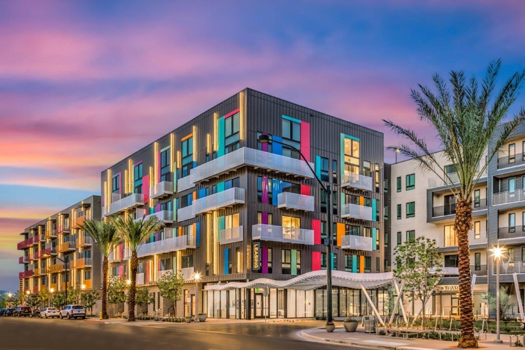 a building with colorful windows and a sunset in the background