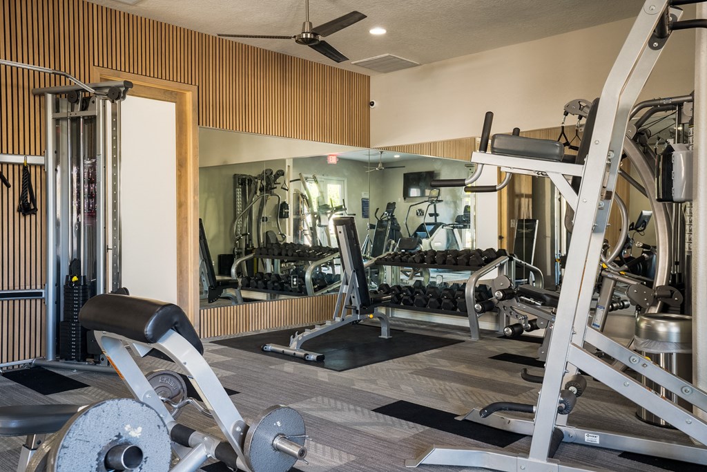 a gym with a lot of machines and weights