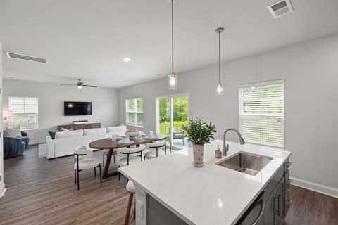 A modern kitchen with a dining table and chairs.