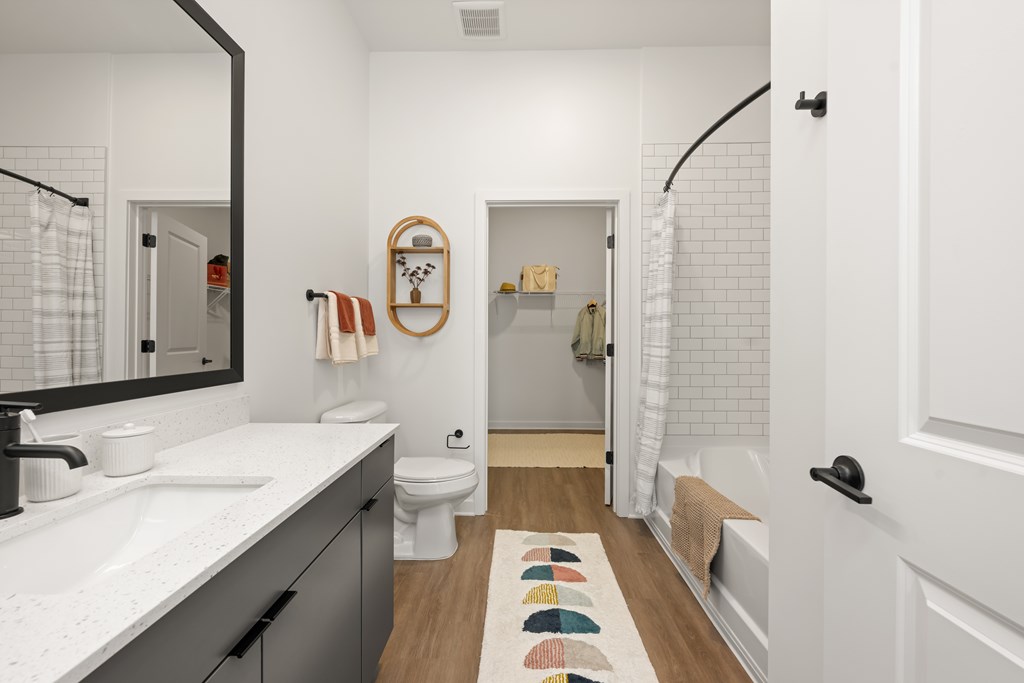 A bathroom with a white sink, toilet, and a mirror.