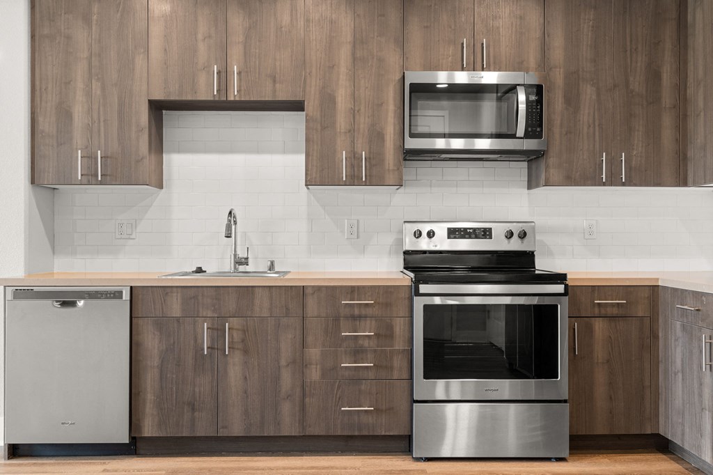 a kitchen with wooden cabinets and stainless steel appliances