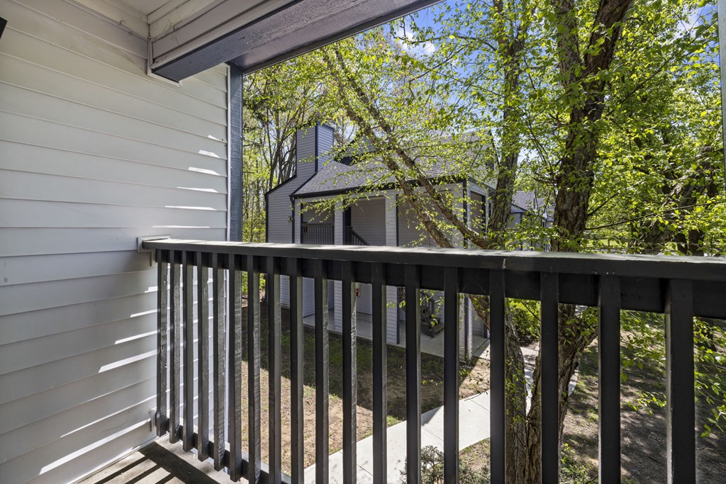 a balcony with a view of apartments and trees